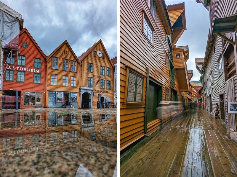 Πολύχρωμα ξύλινα σπίτια στο Bryggen του Μπέργκεν, Νορβηγία, με αντανάκλαση στο βρεγμένο πλακόστρωτο και παραδοσιακά σοκάκια.