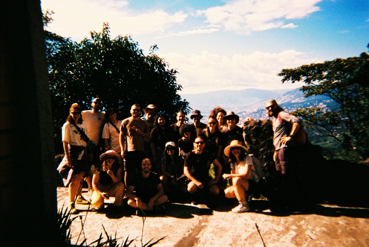 Ομαδική φωτογραφία Altervan παρέας με φόντο την πόλη του Μεδεγίν στα βουνά.