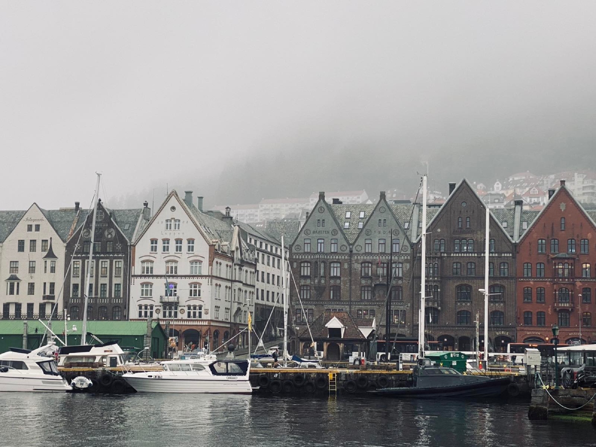 Το Bryggen στο Μπέργκεν στη Νορβηγία, ιστορικά ξύλινα κτίρια και σκάφη στο λιμάνι μέσα στην ομίχλη