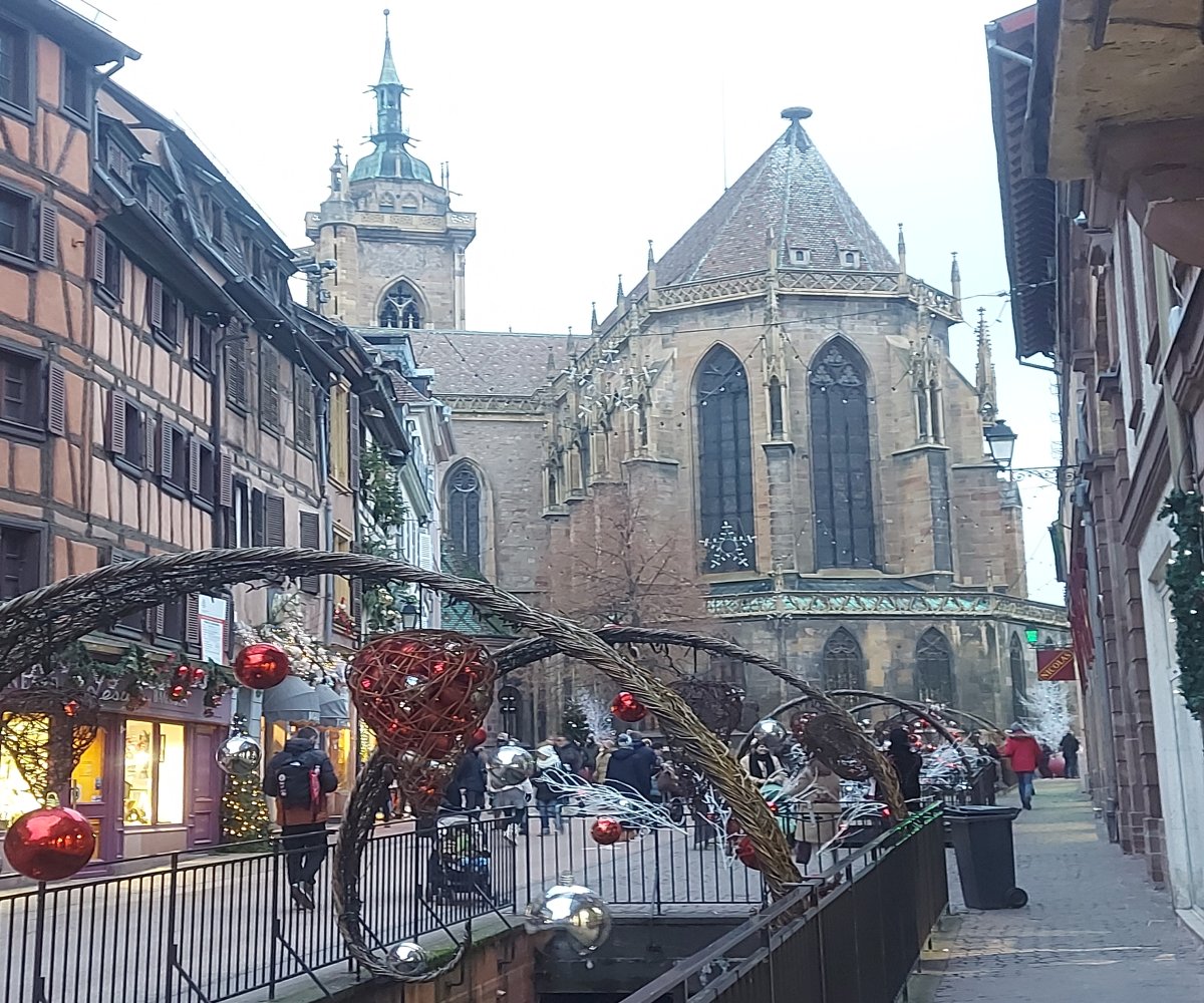 Εκκλησία Saint-Martin στο Κολμάρ, από στενό της Παλιάς Πόλης με χριστουγεννιάτικο στολισμό και σπίτια με ξύλινο σκελετό