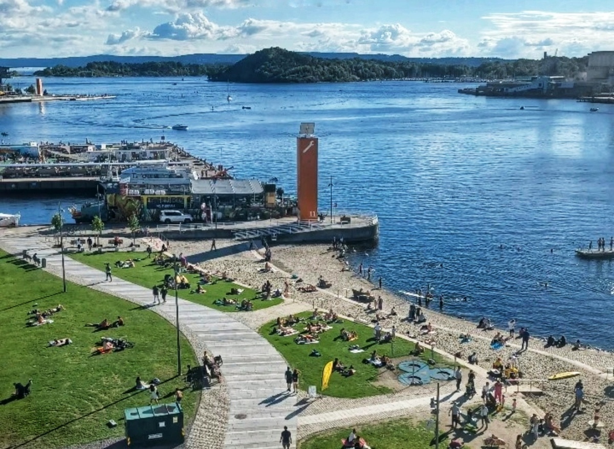 Καλοκαιρινή ημέρα στο Όσλο με κόσμο που χαλαρώνει στο γρασίδι και κολυμπά στο Oslofjord