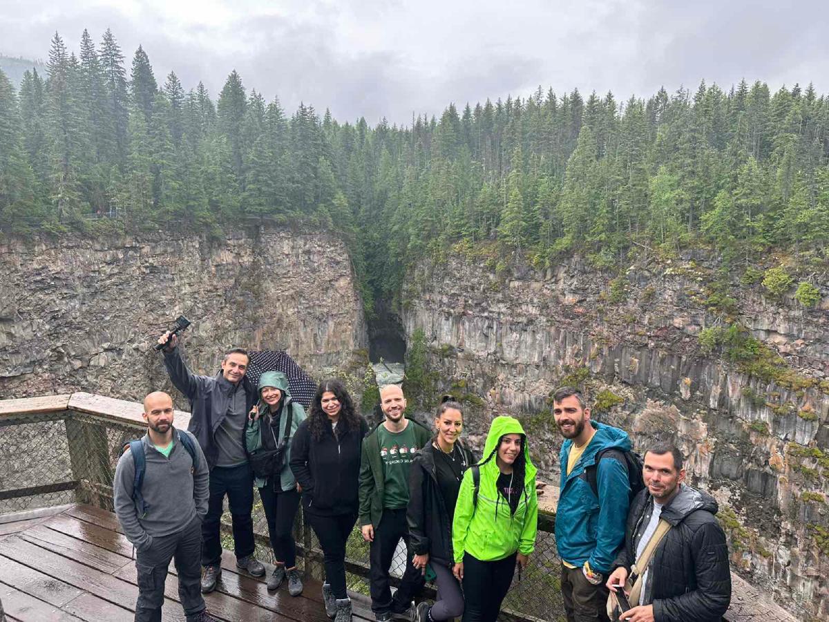 Παρέα ταξιδιωτών σε roadtrip σε viewpoint με θέα φαράγγι και δάσος.