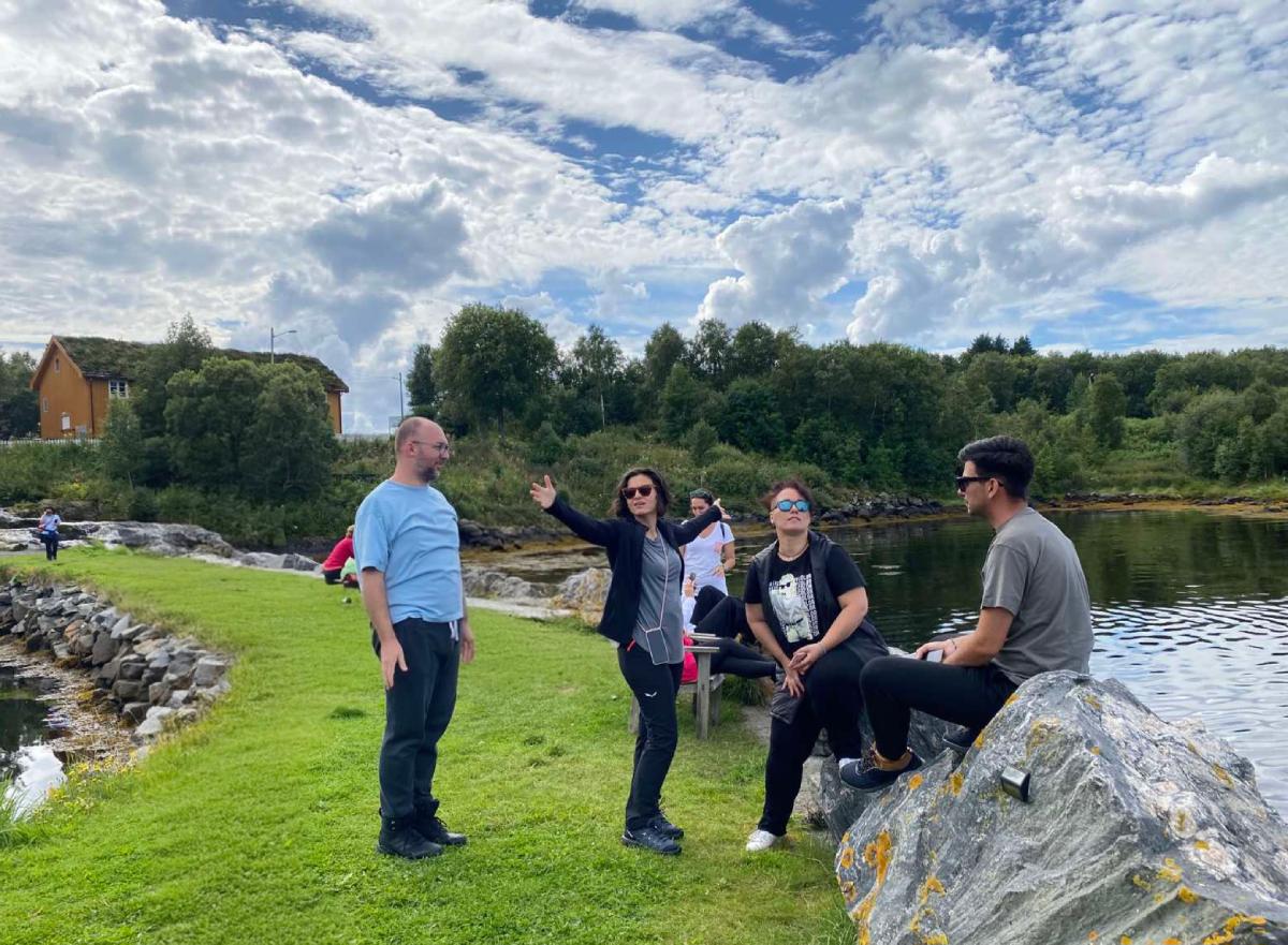 Μικρή παρέα ταξιδιωτών χαλαρώνει και συζητά δίπλα στο νερό σε roadtrip