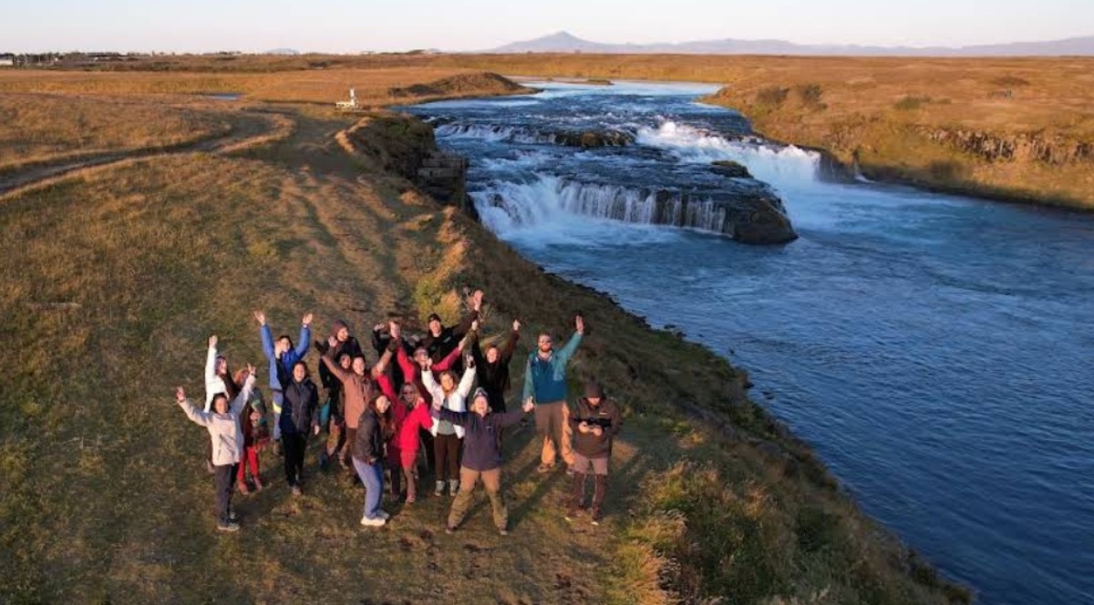 Μικρή παρέα ταξιδιωτών σε roadtrip δίπλα σε ποτάμι και καταρράκτη στη φύση