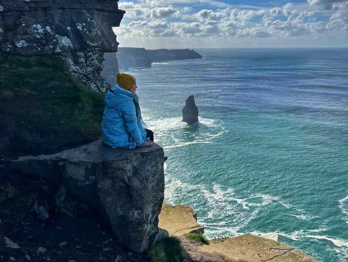 Solo traveller σε βράχια με θέα τη θάλασσα κατά τη διάρκεια ταξιδιού.